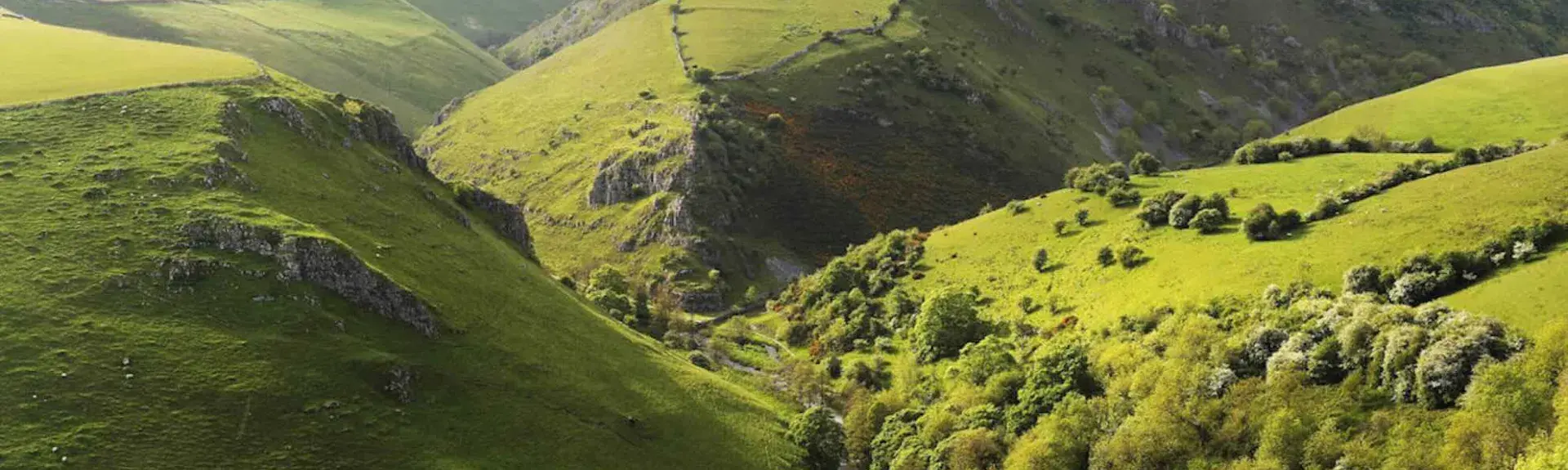 An aerial of Peak District hills and valleys.