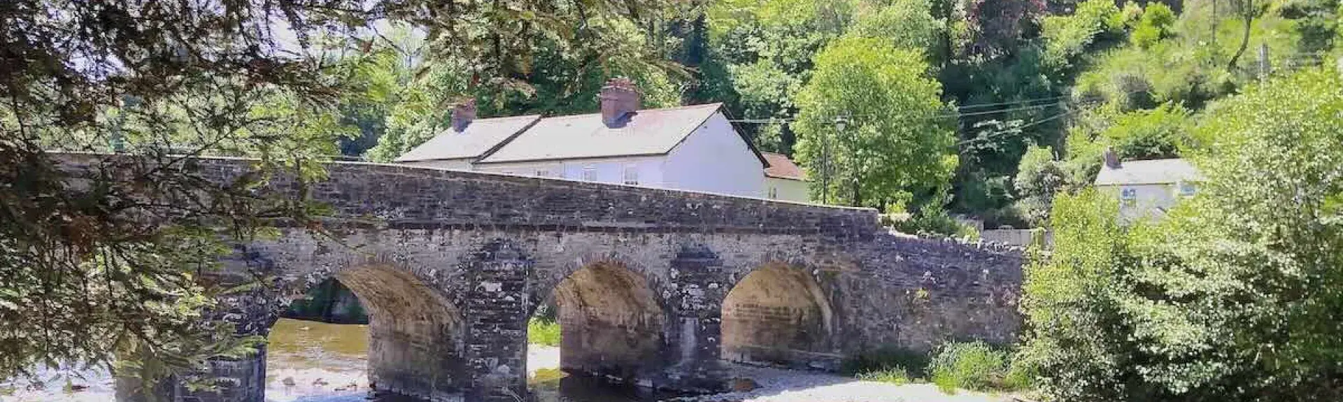 A 5-arched stone bridge crosses the wide shallow River Barle in Dulverton. 