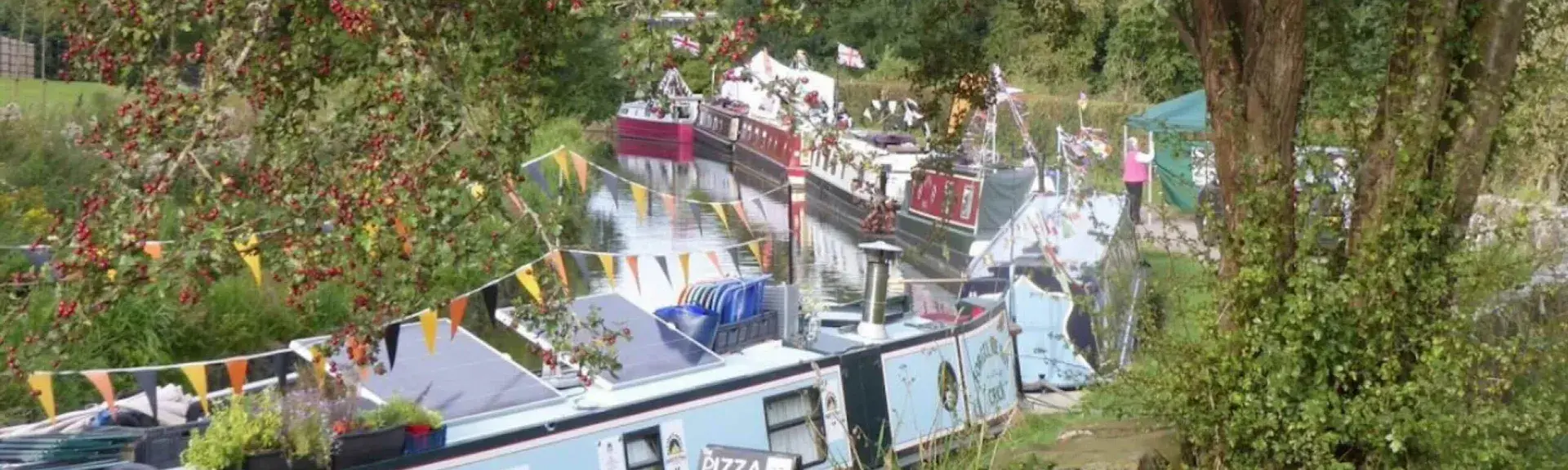 Brightly painted narrow boats line the towpath at a Shropshire Canal Festival.