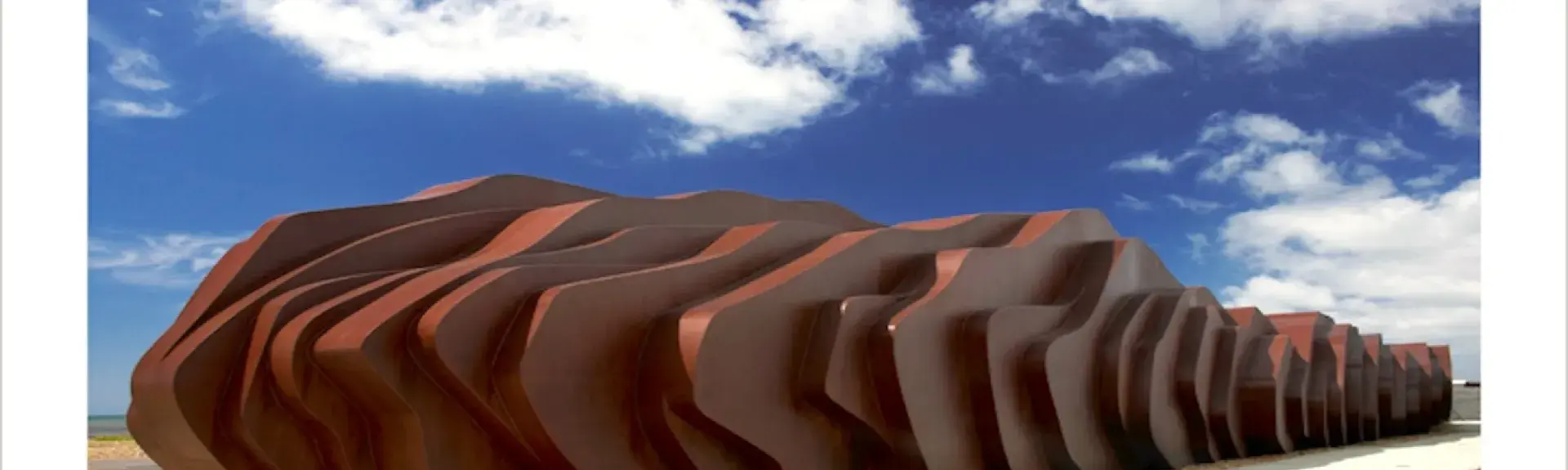  A large wooden beach sculpture - the exterior of a beach cafe in Seaton.