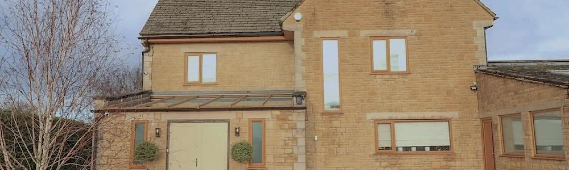 A Cotswold contemporary honeystone cottage overlooks a large shingled courtyard.