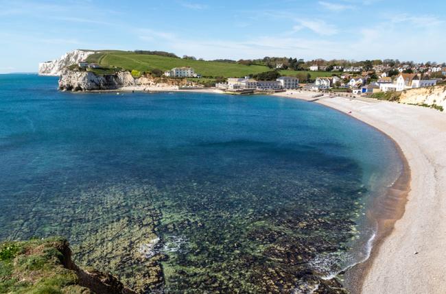 Freshwater Bay - a deep blue sea is fringed by a curving beach of white sand leading to a headland.