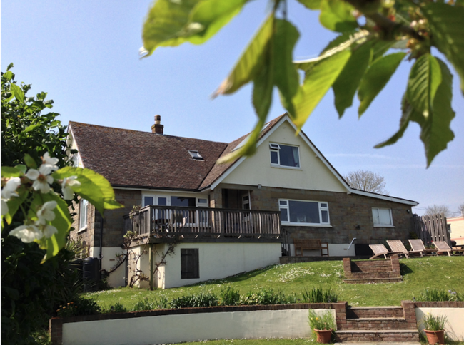 A modern Isle of Wight holiday home with a large gable end surrounded by lawns