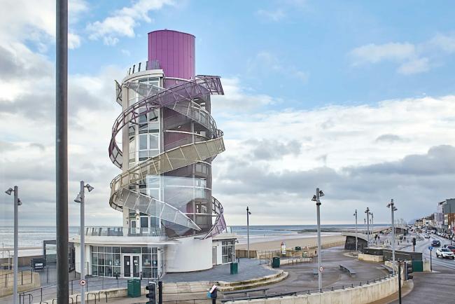 A large, modern helter-skelter overlooks a sandy beach in Redcar.