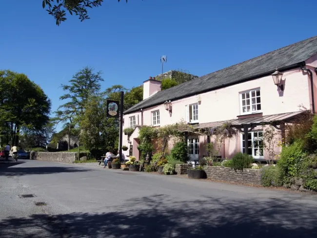 A Dartmoor village pub overlooks an empty street on a sunny day in Lydford.