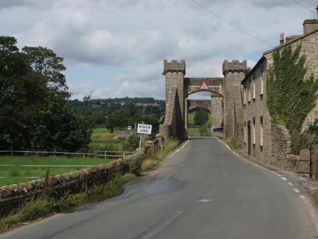 The road entering Leyburn runs under a stone-built arch.