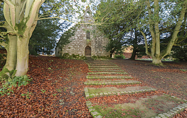 An old chapel in the woods is approached by a flight of wide, cobbled steps