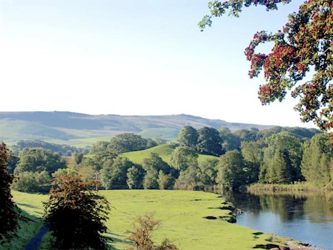 A still river winds through tree-lined fields.