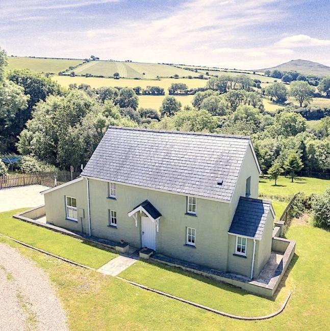 A remote holiday cottage in an isolated rural location surrounded by trees and fields.