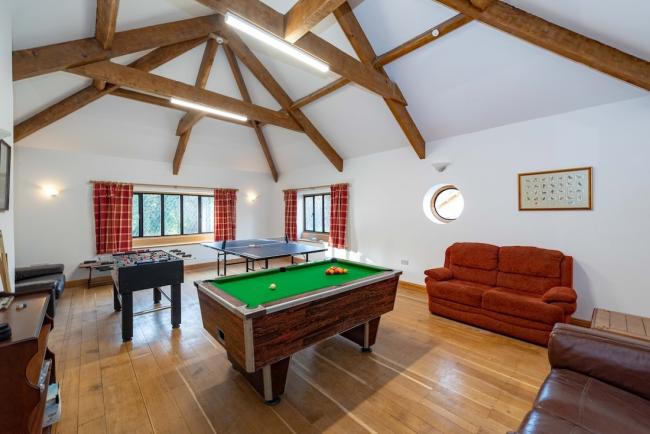 A holiday cottage games room with table football, table tennis an pool tables. in a games room.