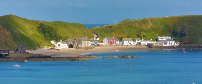 A tiny Welsh village nestles between steep hills and a beach overlooking the sea.