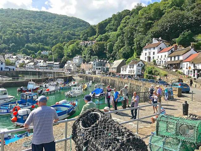 Lynmouth harbour at high tide nestles beneath step-wooded hills.