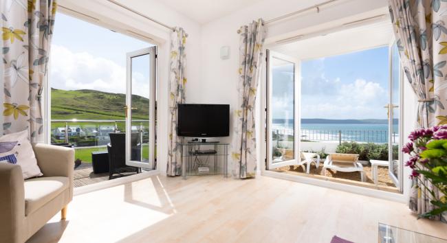 Sea views through two set of French windows from the lounge of a holiday home above Woolacombe beach.