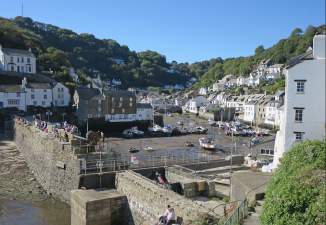 Fishermen's cottages line the quayside of Polperro harbour at low tide