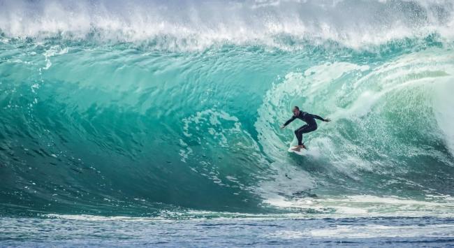 A surfer traverses a large wave.